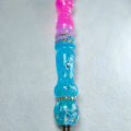 Détail des finitions pailletées roses et bleues du stylet artisanal