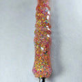 Détail des paillettes multicolores sur le manche rose doré