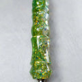 Détail des paillettes vertes et dorées sur le manche du stylet