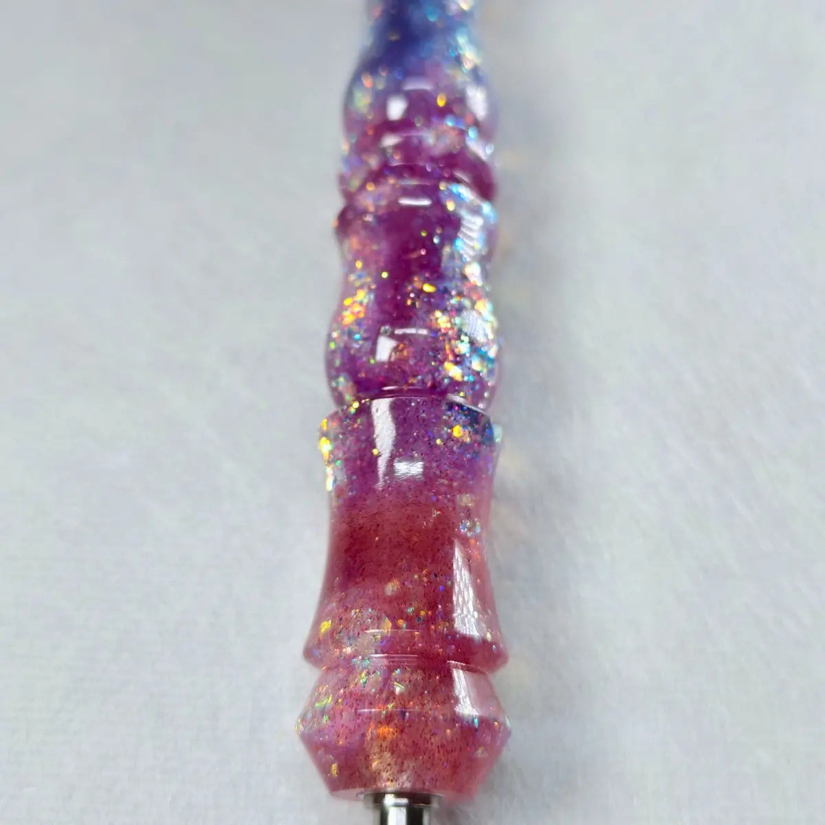 Gros plan sur le manche violet Galaxy pailleté du stylet fait main