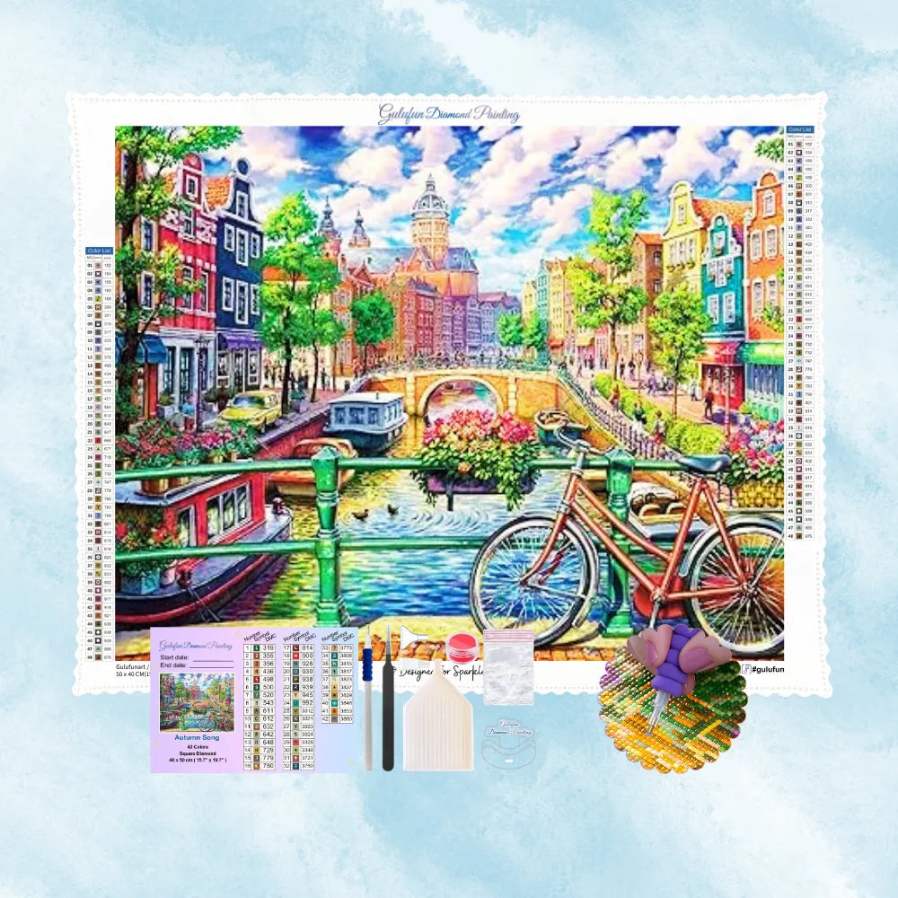 Kit de broderie diamant montrant un canal de ville européenne, des bâtiments colorés et un vélo.