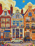 Rendu pixelisé d'un kit broderie diamant représentant des maisons colorées et une petite voiture vintage.