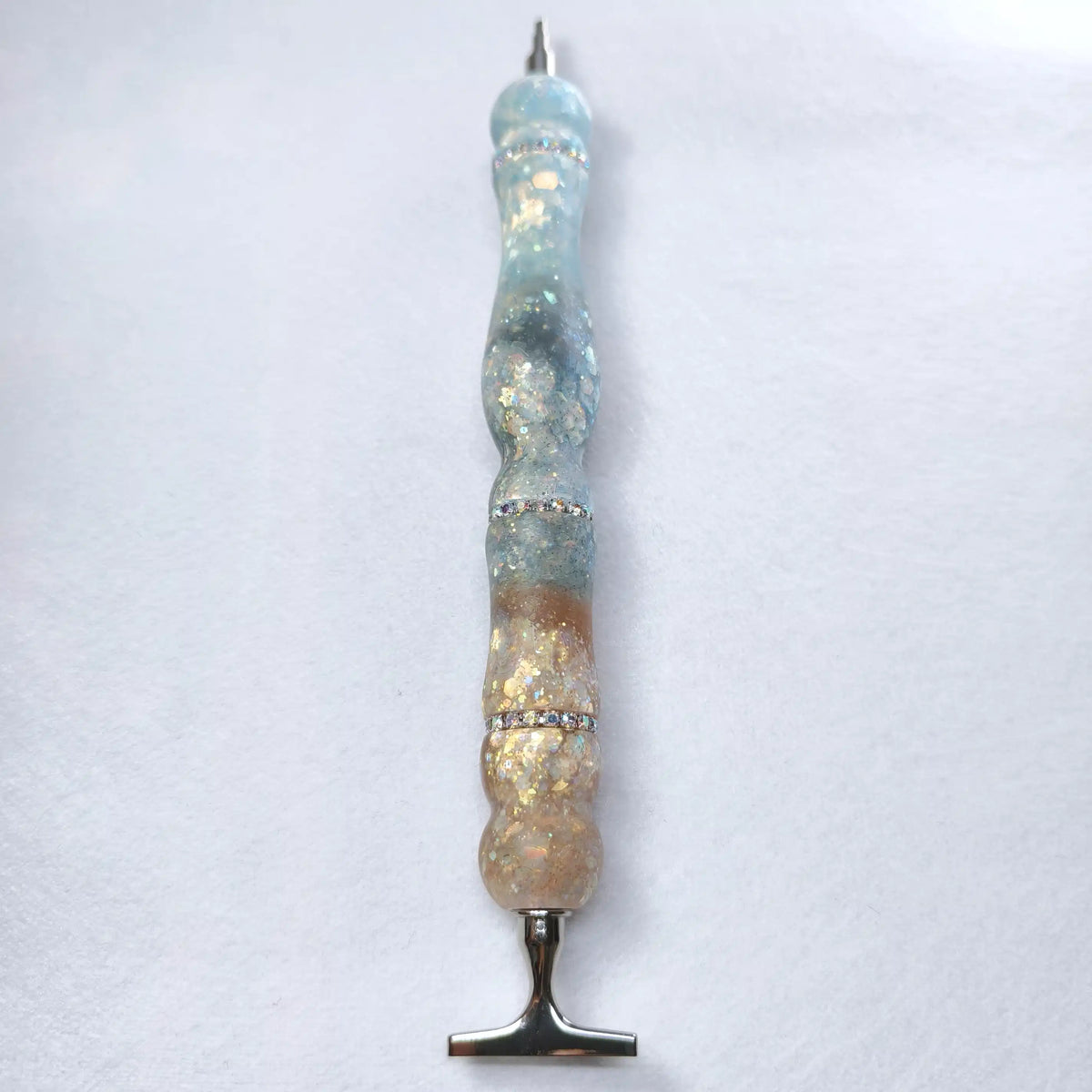 Stylo d'art en résine au toucher satiné dégradé bleu glacier et ambre avec 3 anneaux incrustés de strass scintillants.