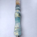 Texture satinée effet verre dépoli du stylo bleu glacier avec inclusions de paillettes opales et anneau en strass.